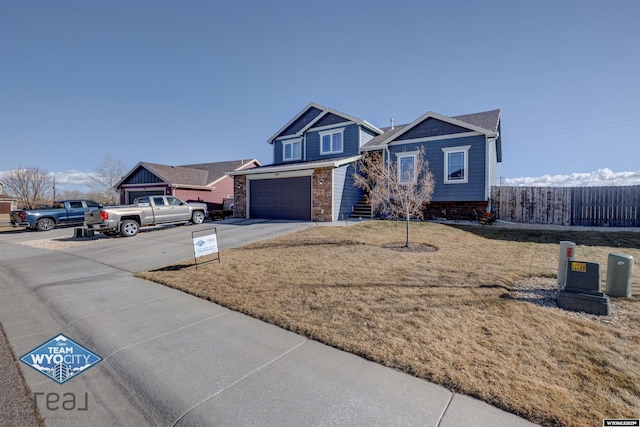 view of front of home with a front yard, concrete driveway, fence, and an attached garage