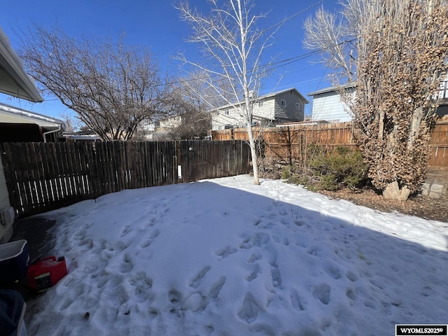 snowy yard featuring fence