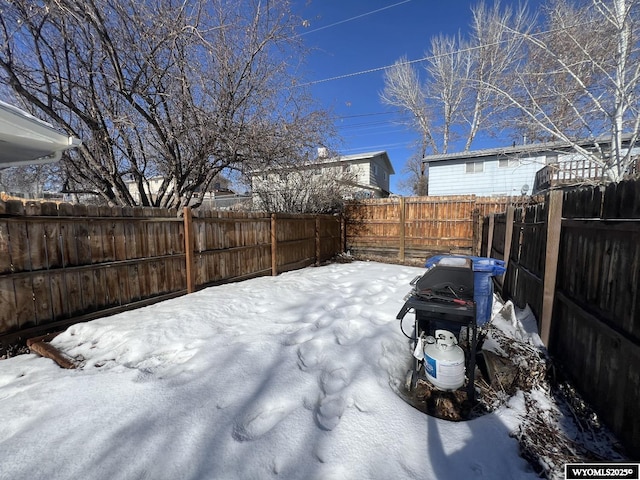 yard covered in snow with a fenced backyard