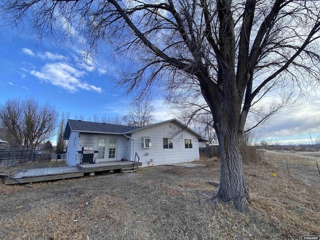 rear view of property with a wooden deck and fence