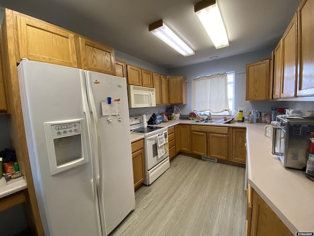 kitchen featuring brown cabinets, light wood-type flooring, white appliances, and light countertops