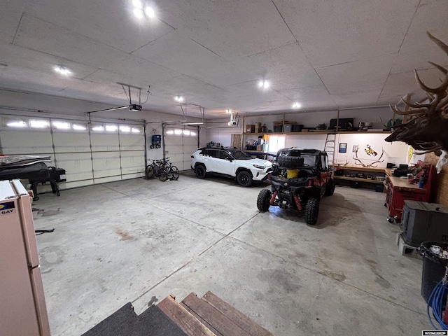 garage with freestanding refrigerator and a garage door opener