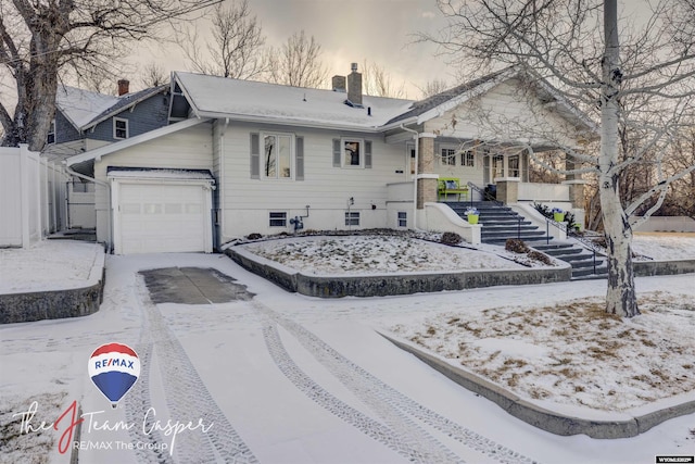 exterior space featuring a garage, stairway, driveway, and a chimney