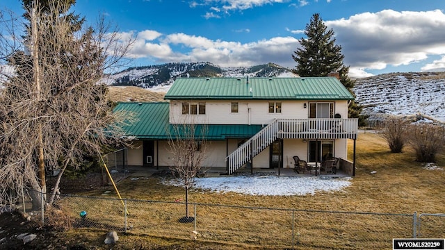 rear view of property with fence private yard, stairway, metal roof, and a patio