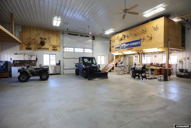 garage with a ceiling fan, a workshop area, and metal wall