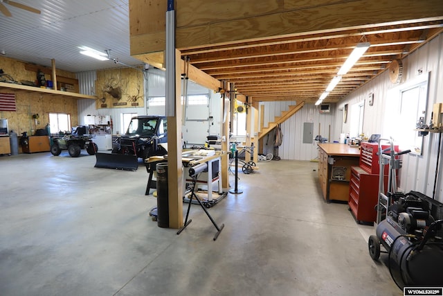 below grade area featuring a healthy amount of sunlight, electric panel, and a workshop area