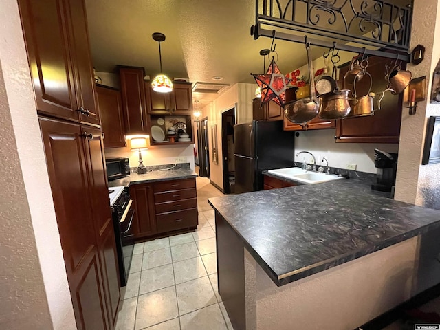 kitchen with dark countertops, light tile patterned flooring, a sink, a peninsula, and black appliances