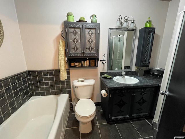 full bath featuring toilet, a garden tub, vanity, and tile patterned floors