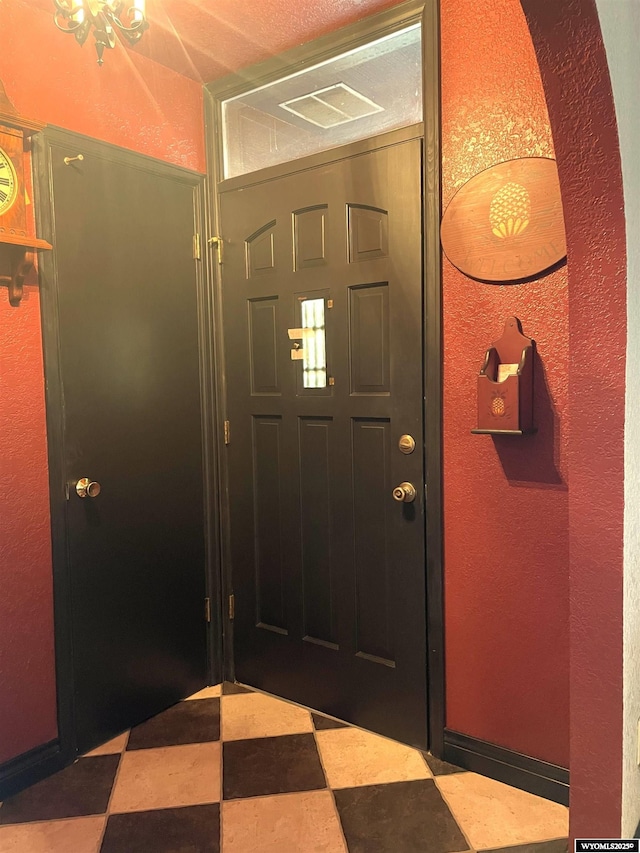 foyer entrance featuring baseboards and tile patterned floors