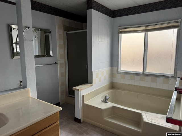 full bath featuring a garden tub, vanity, and a shower stall