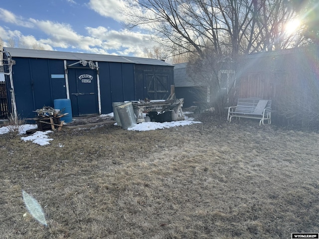 view of yard featuring a storage shed, fence, and an outbuilding