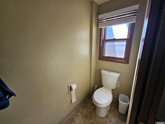 bathroom featuring toilet and baseboards