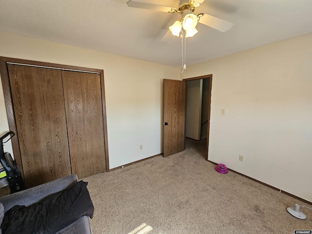 bedroom featuring a closet, light carpet, ceiling fan, and baseboards