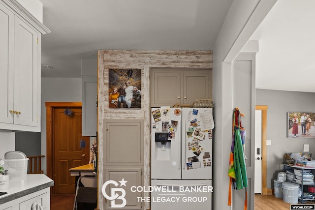 kitchen featuring white refrigerator with ice dispenser and light wood-style flooring