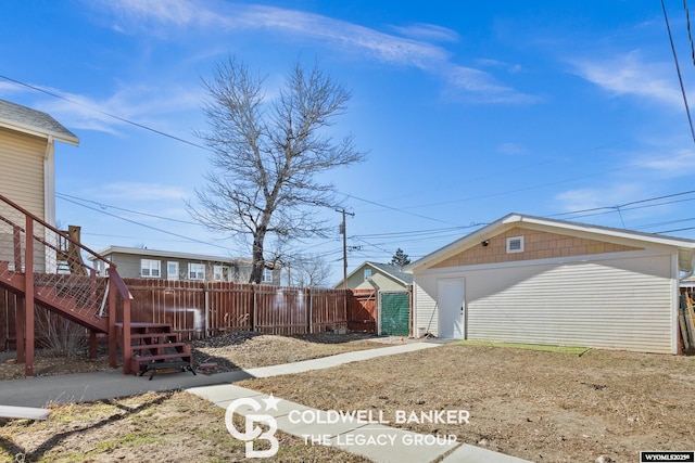 view of yard with stairway, fence, and an outbuilding