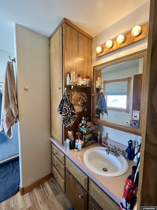 bathroom with vanity, baseboards, and wood finished floors