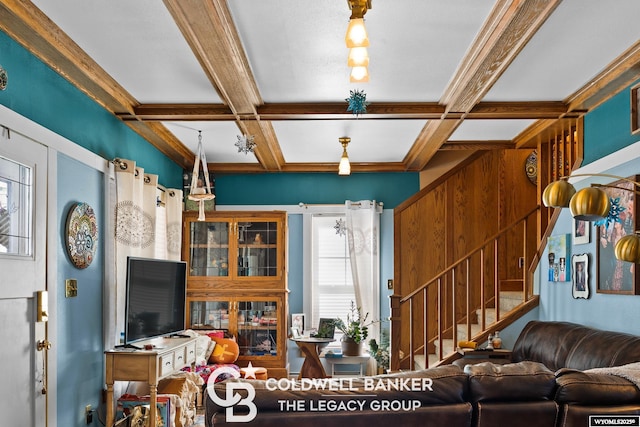 living area featuring beam ceiling, coffered ceiling, and stairs