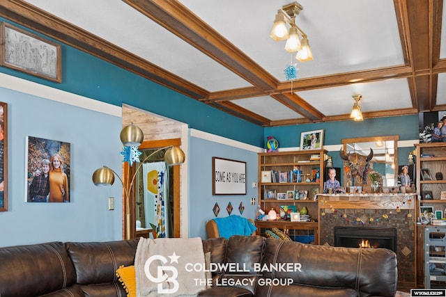 living area featuring beam ceiling, coffered ceiling, and a tiled fireplace