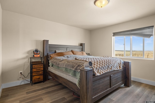 bedroom with wood finished floors and baseboards