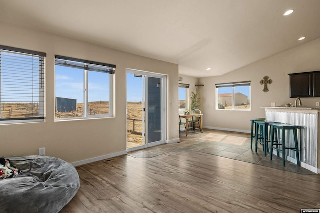 living area featuring baseboards, a healthy amount of sunlight, and light wood finished floors