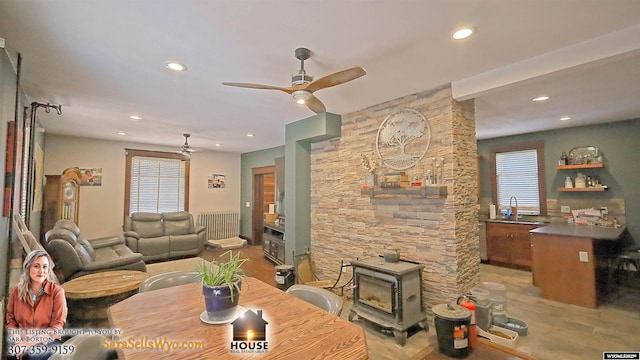 dining space featuring light wood-style flooring, recessed lighting, a wood stove, and a ceiling fan