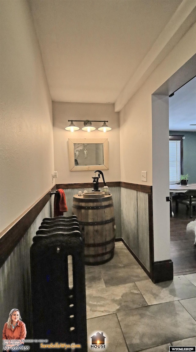 bathroom featuring wood walls and wainscoting