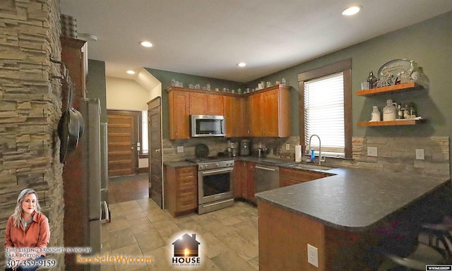 kitchen featuring stainless steel appliances, a peninsula, a sink, brown cabinets, and dark countertops