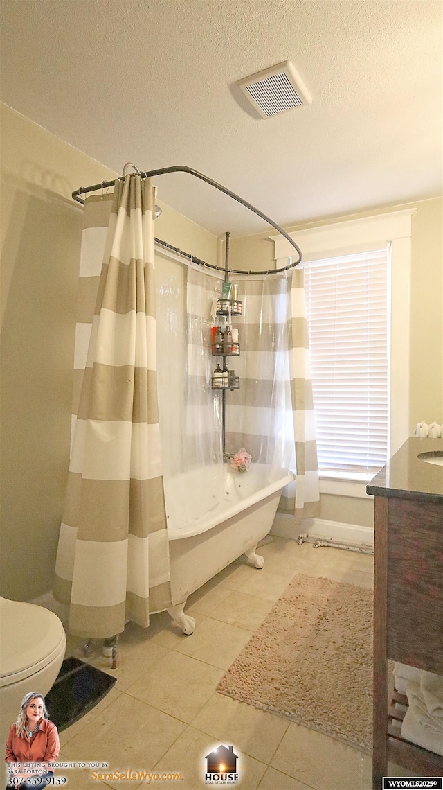 full bath featuring tile patterned flooring, visible vents, a textured ceiling, and toilet