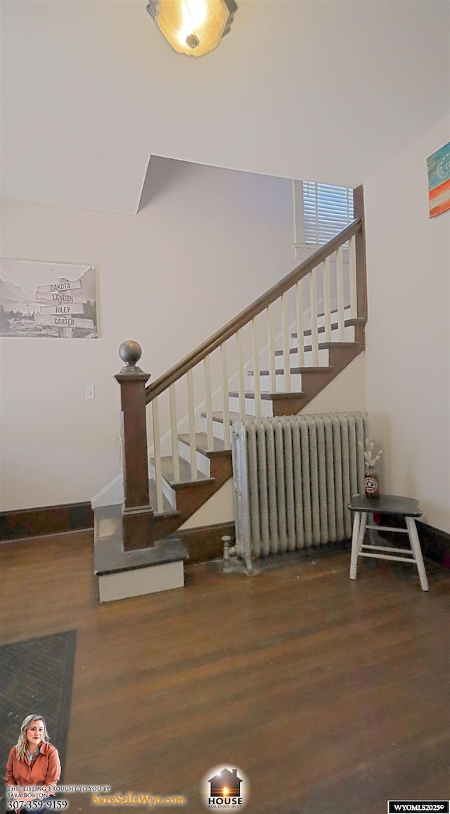 stairway featuring radiator heating unit, wood finished floors, and baseboards