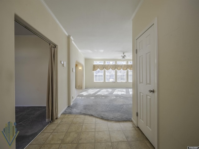 hallway with light carpet, ornamental molding, and baseboards