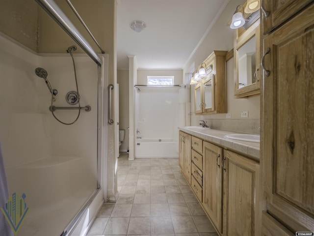 bathroom featuring toilet, double vanity, a shower, and a sink