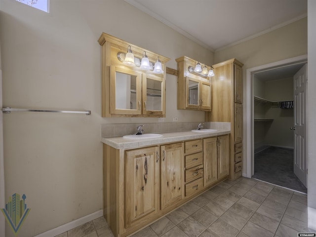 full bath with double vanity, ornamental molding, a sink, and a walk in closet