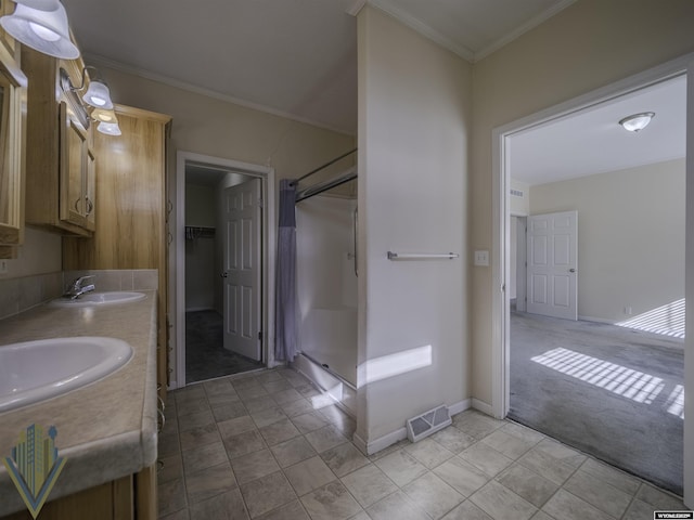 full bath featuring crown molding, visible vents, and a sink