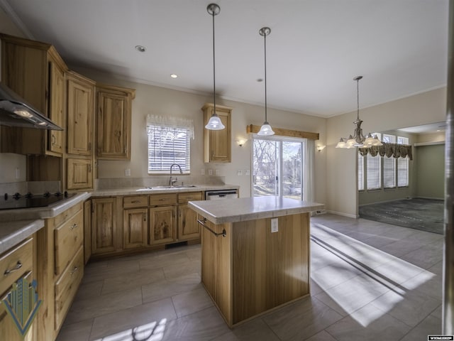 kitchen with black electric stovetop, a sink, light countertops, a center island, and decorative light fixtures