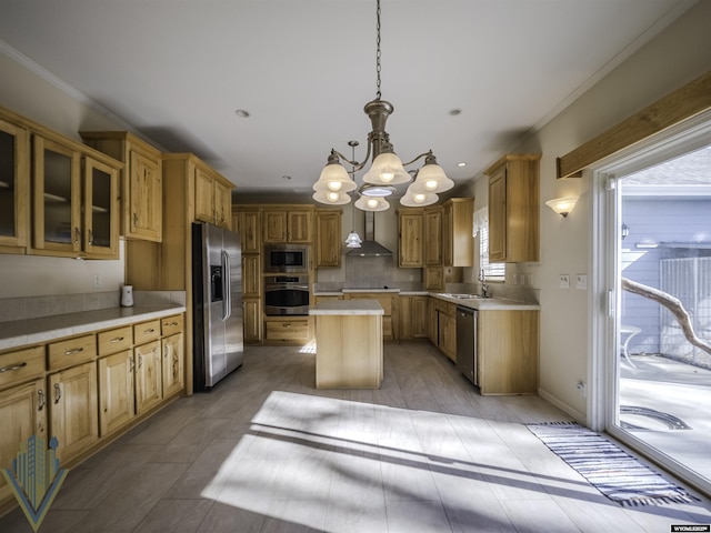 kitchen with a center island, stainless steel appliances, light countertops, a sink, and wall chimney range hood