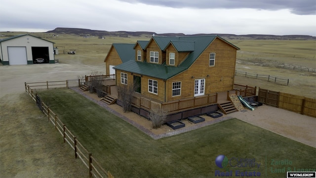 1596 Rd 109, Cheyenne, WY 82009 - rear view of house featuring a rural view, an outdoor structure, metal roof, fence, and a garage