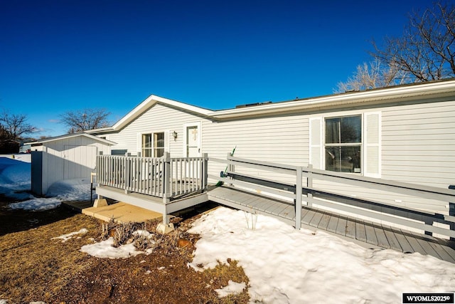 back of house featuring an outdoor structure and a wooden deck