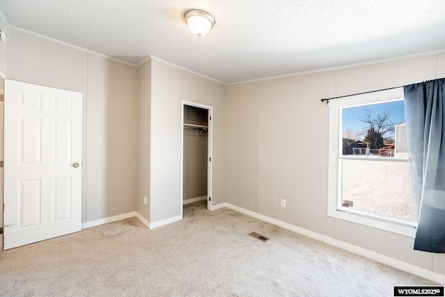 unfurnished bedroom featuring ornamental molding, multiple windows, carpet flooring, and visible vents