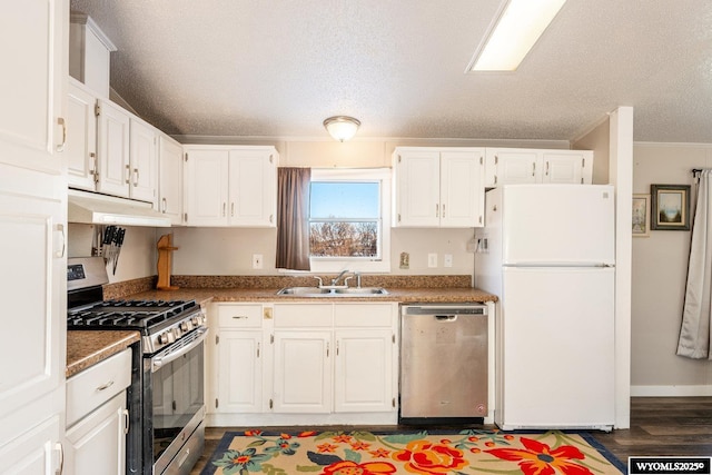 kitchen with stainless steel appliances, white cabinets, a sink, and under cabinet range hood