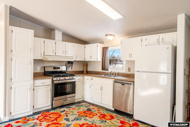 kitchen with appliances with stainless steel finishes, white cabinets, a sink, and under cabinet range hood