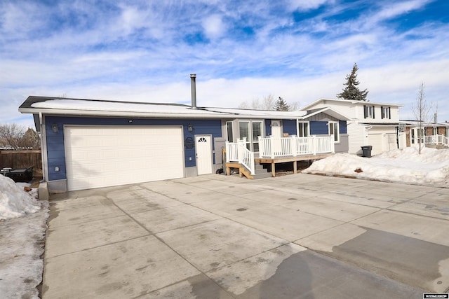 view of front of house featuring a garage, concrete driveway, and a wooden deck