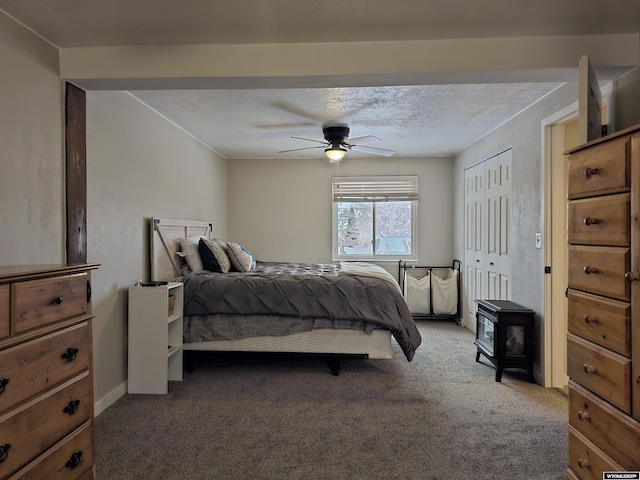 carpeted bedroom featuring a textured ceiling, a closet, a ceiling fan, and baseboards