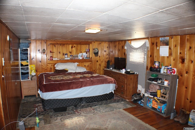 bedroom featuring wood walls and wood finished floors