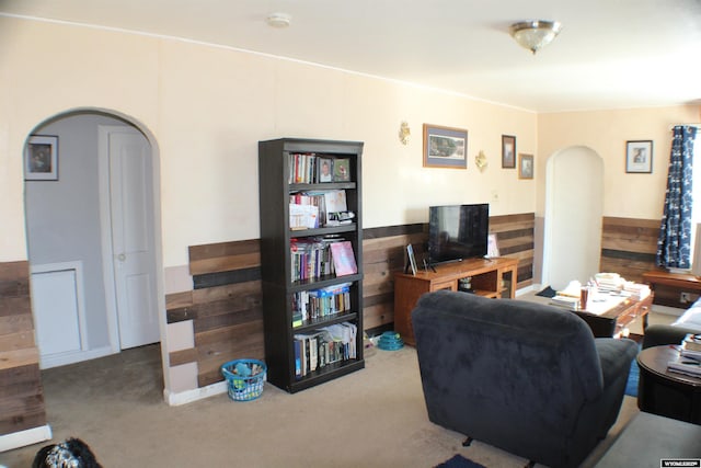 carpeted living room featuring arched walkways