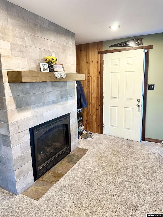 living room with a tile fireplace and carpet flooring