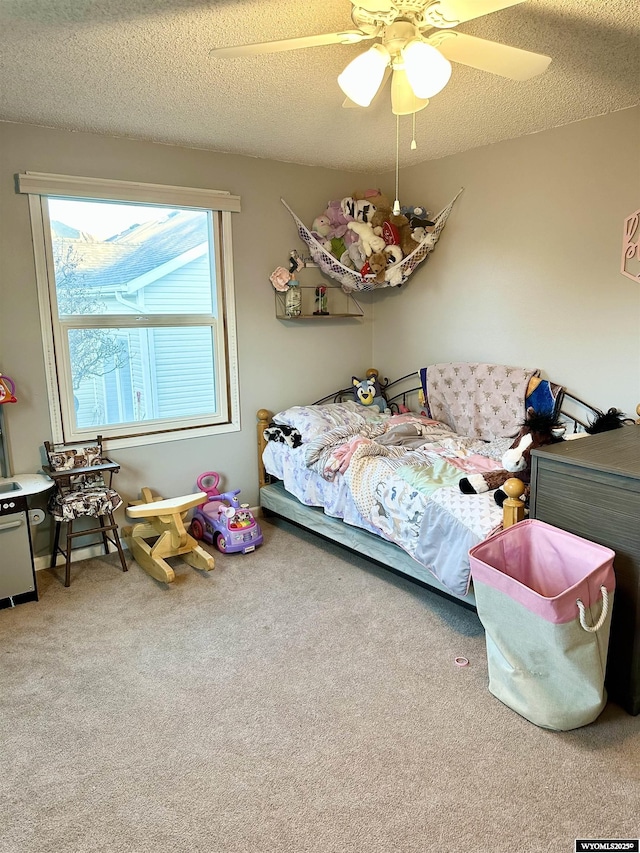 carpeted bedroom featuring a textured ceiling and ceiling fan