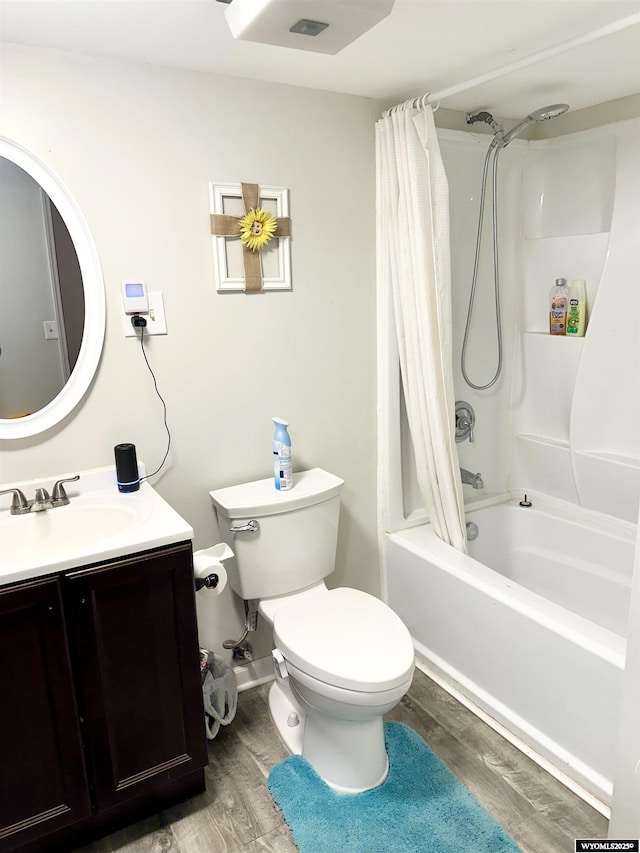 bathroom featuring toilet, shower / tub combo with curtain, wood finished floors, and vanity