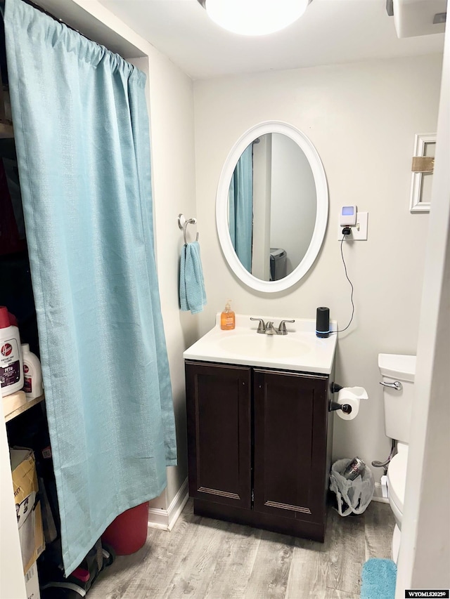 bathroom with vanity, wood finished floors, and toilet