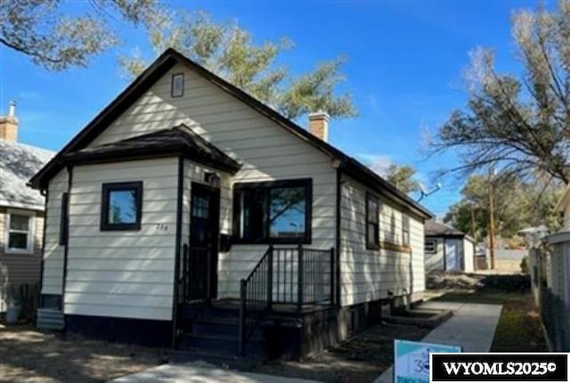 rear view of property featuring a chimney