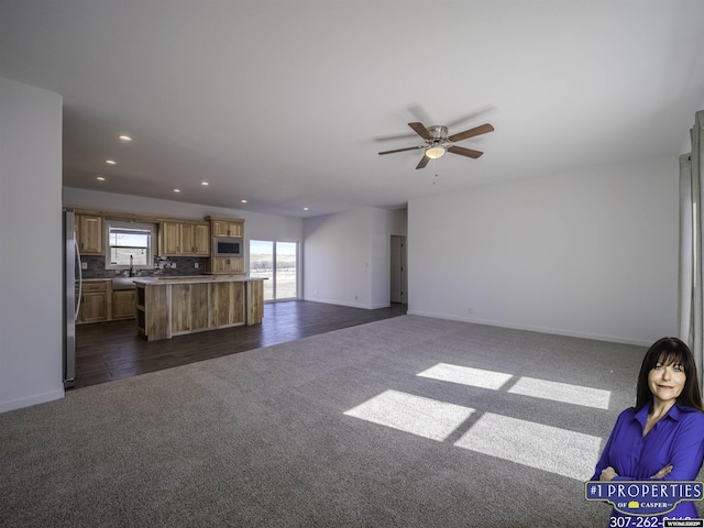 unfurnished living room with baseboards, dark colored carpet, ceiling fan, and recessed lighting